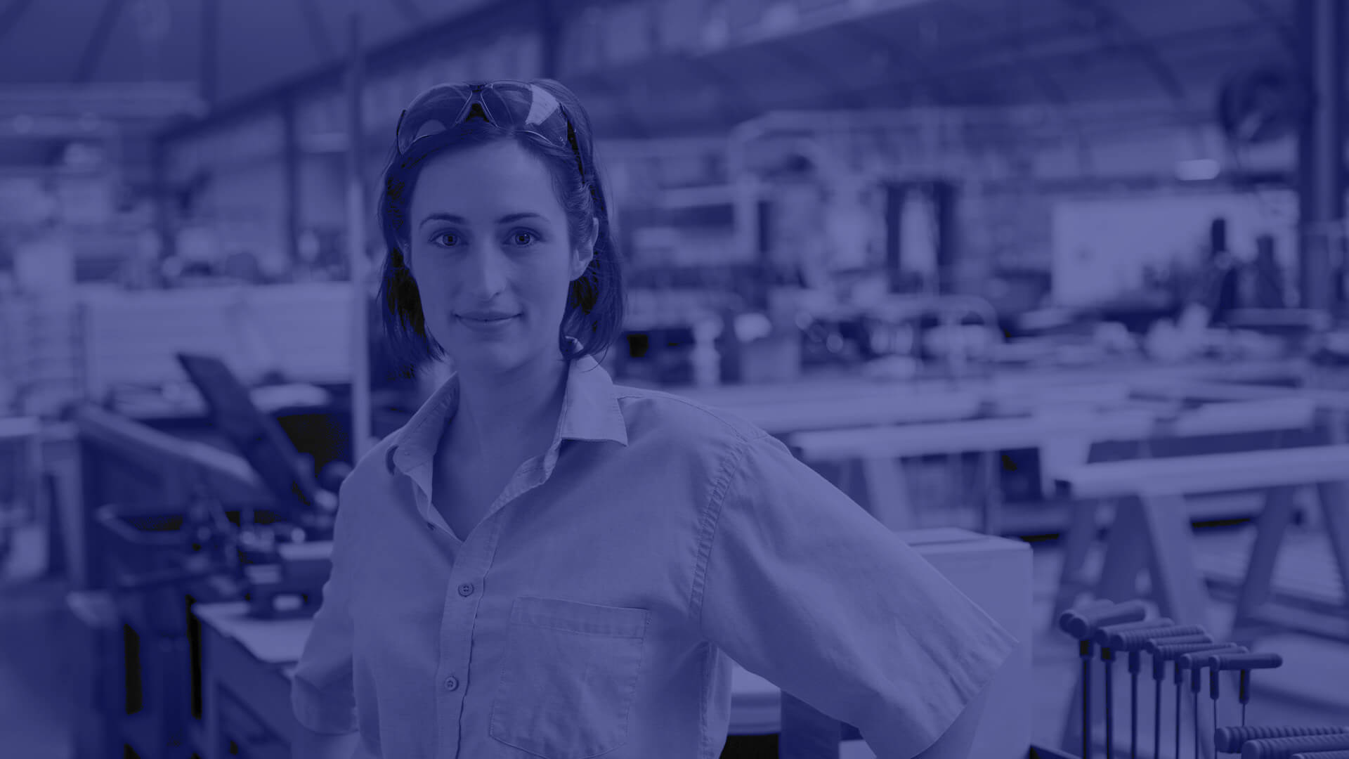 A female energy worker standing with safety glasses on her head